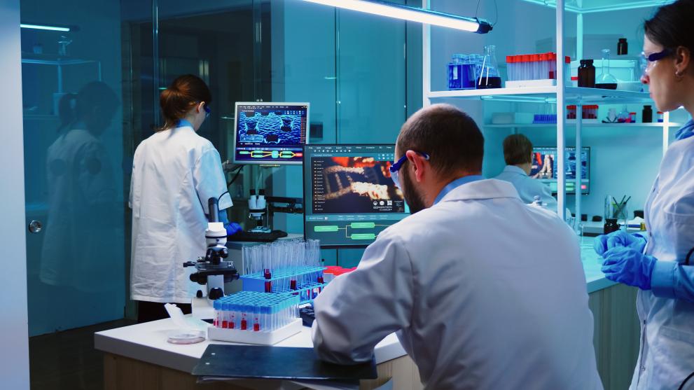 Scientists coworkers working in chemical modern equipped laboratory at night analysing test results. 
