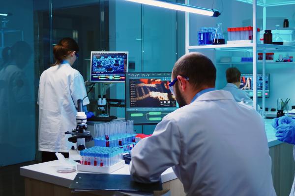 Scientists coworkers working in chemical modern equipped laboratory at night analysing test results. 