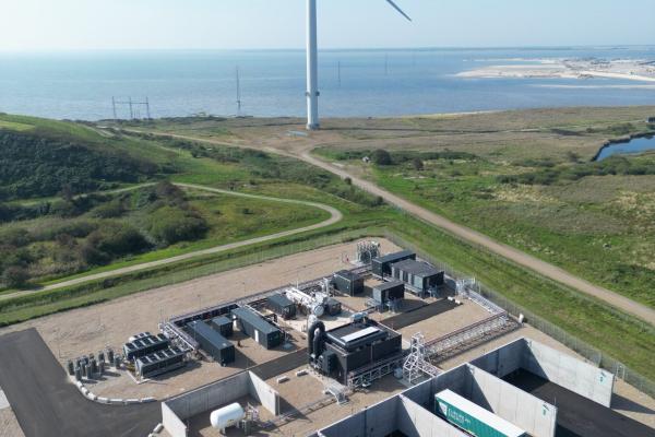 Aerial view of the Måde Power-to-X facility near the coast, featuring a wind turbine and industrial infrastructure supporting the FiBrane project’s seawater-to-UPW conversion for offshore green hydrogen production.